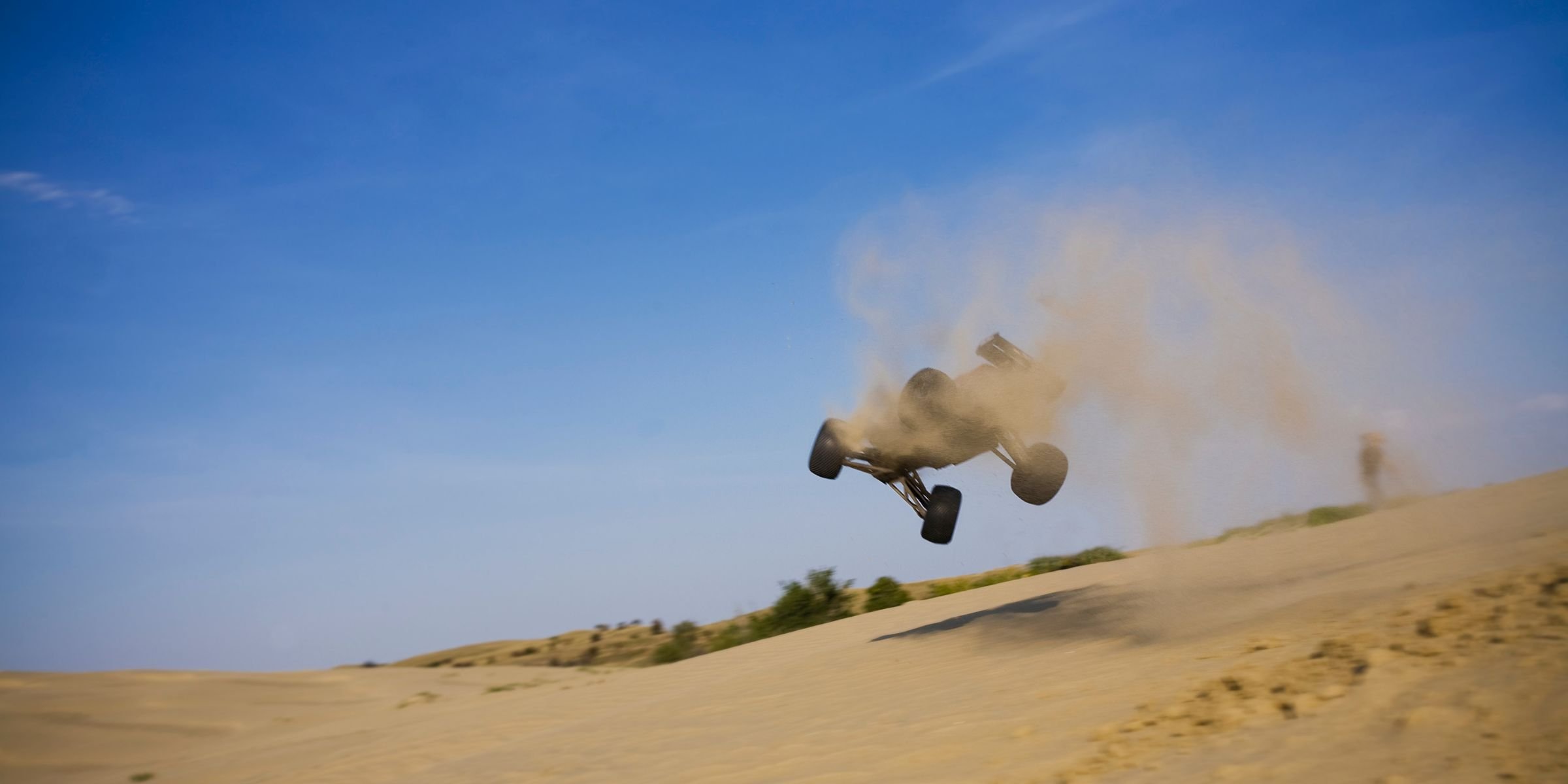 RC buggy mid-jump on dunes
